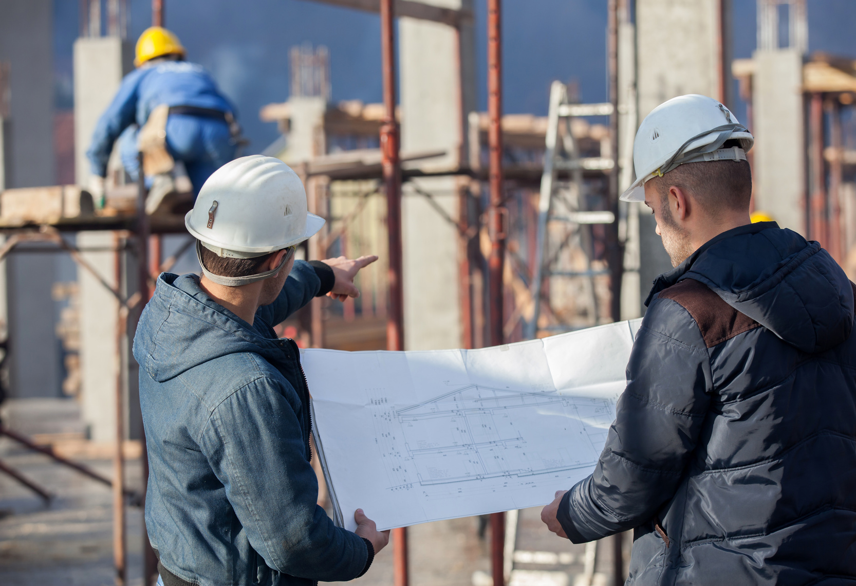 Ingénieurs économistes de la construction examinant un plan d'exécution lors d'une expertise technique à Conflans-Sainte-Honorine.